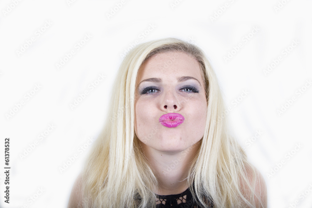 Woman giving a big kiss to the camera (studio portrait) Woman giving a big kiss to the camera (studio portrait)