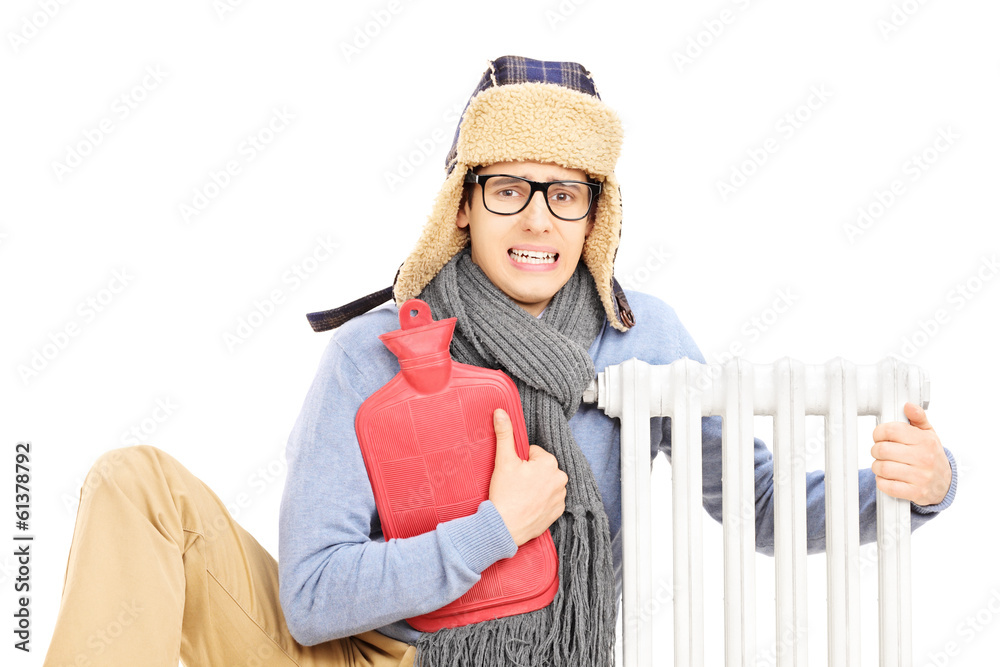 Chilled young man with hot water bottle hugging a radiator Stock Photo ...