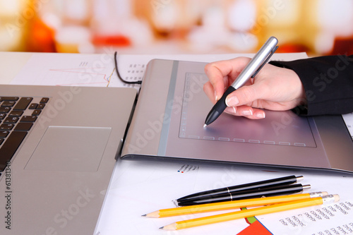 Female hand using graphics tablet on table close up