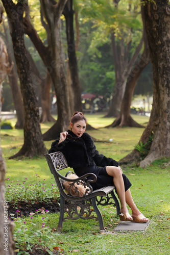 Beautiful Asian lady in black dress, posing in the park, greener