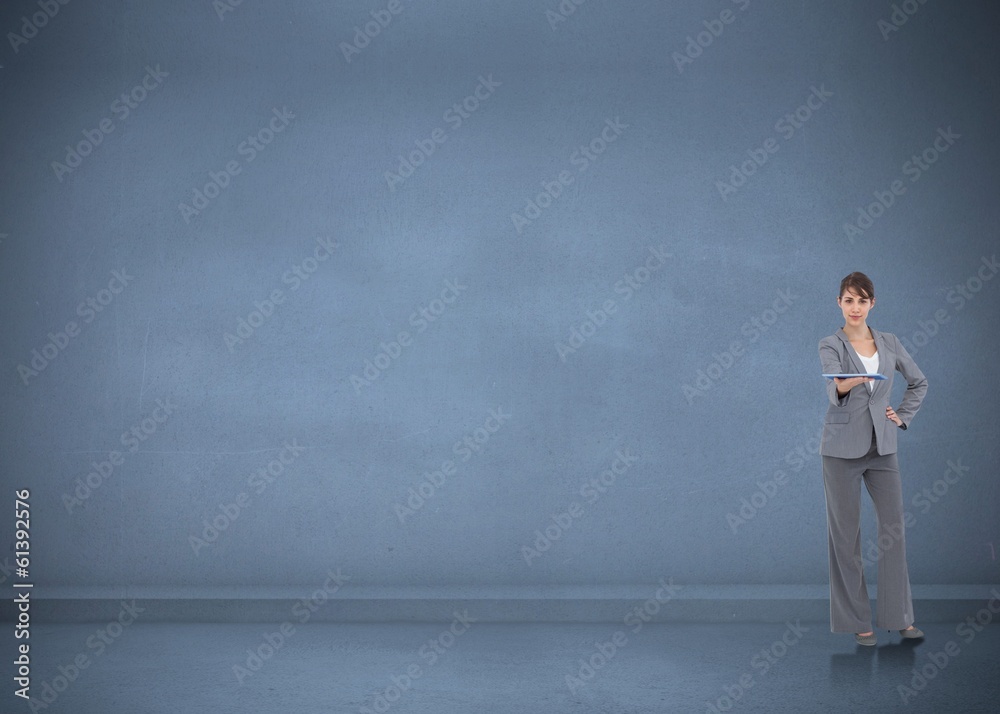 Composite image of attractive businesswoman holding tablet pc Composite image of attractive businesswoman holding tablet pc