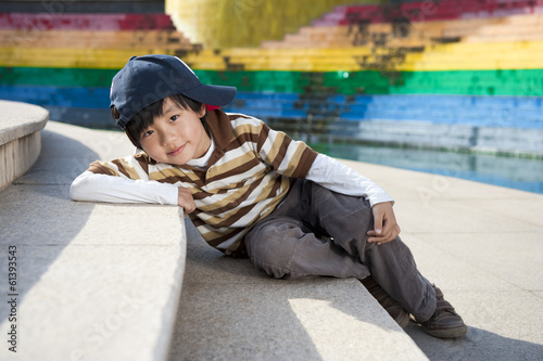 Cute Chinese boy model posing for camera on stairs © wusuowei