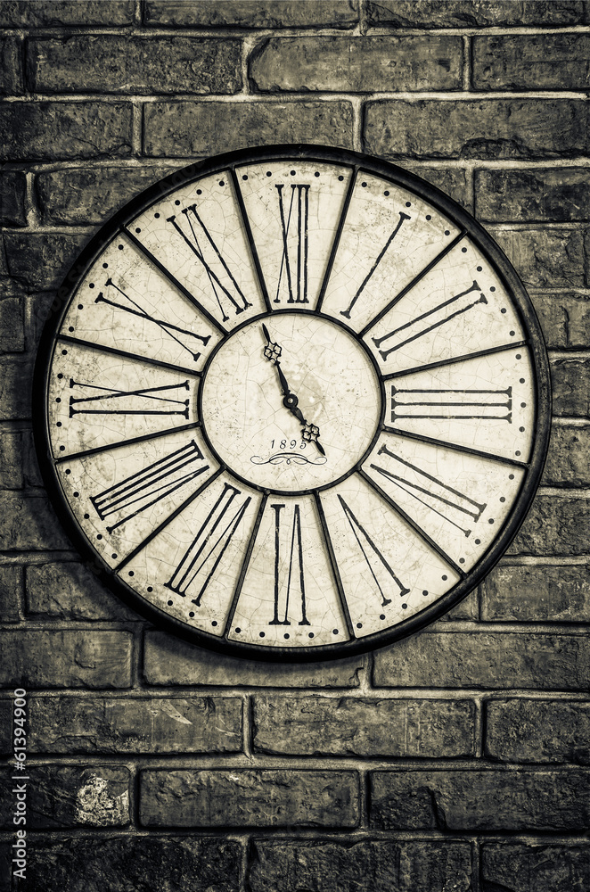 Old vintage clock in monochrome on textured brick wall