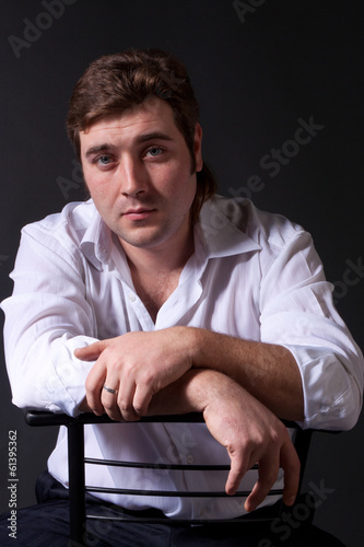 man posing in white shirt on dark background