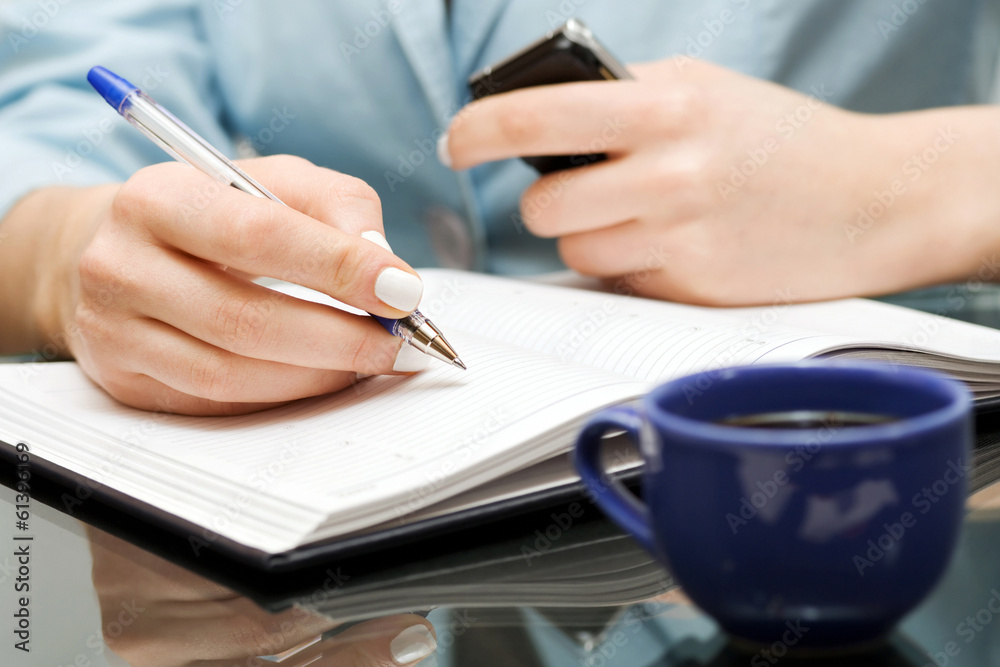 Business woman writing in notebook Business woman writing in notebook