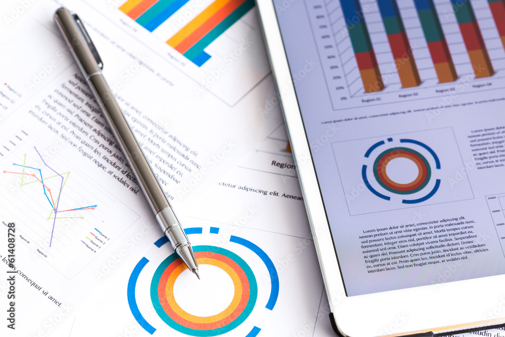 Obraz premium Financial charts on the table with tablet phone and pen