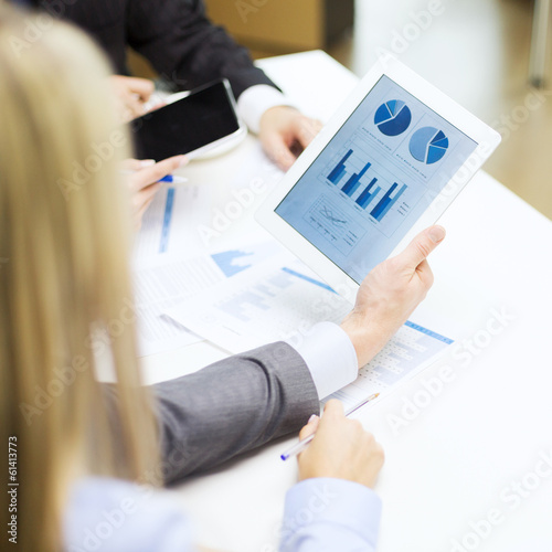 business team with graph on tablet pc screen
