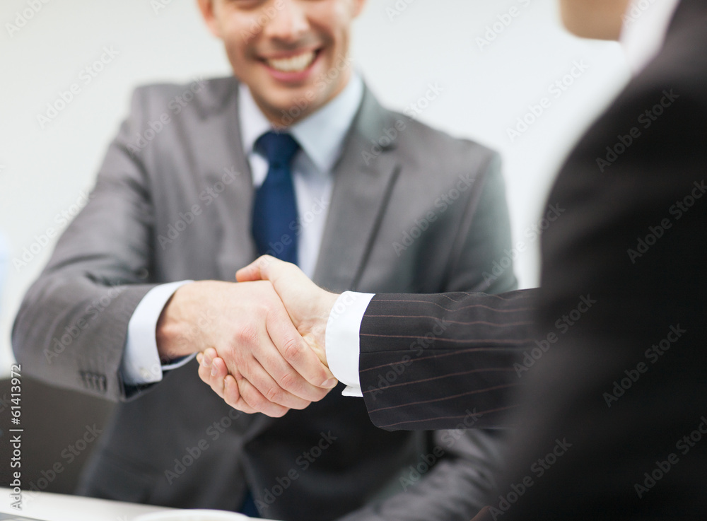 two businessmen shaking hands in office two businessmen shaking hands in office