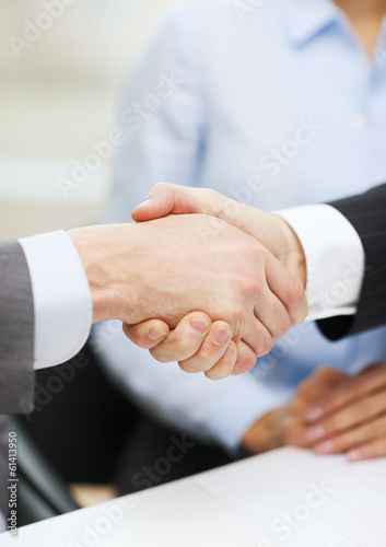 two businessmen shaking hands in office