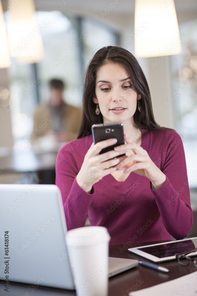 handsome woman using smartphone in a cafe handsome woman using smartphone in a cafe