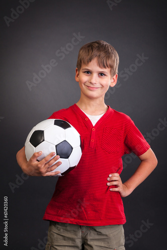 Cute boy is holding a football ball. Soccer ball © Sergii Figurnyi