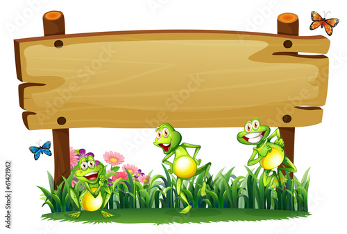 An empty wooden board at the garden with playful frogs