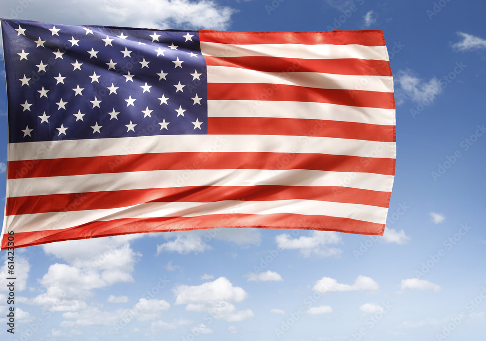 Fototapeta premium American flag flying in blue sky