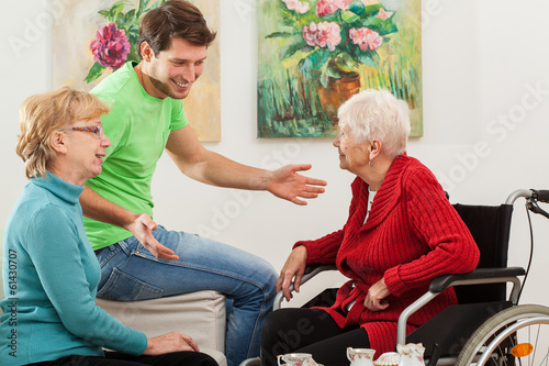 Young man tallking with two older women photo