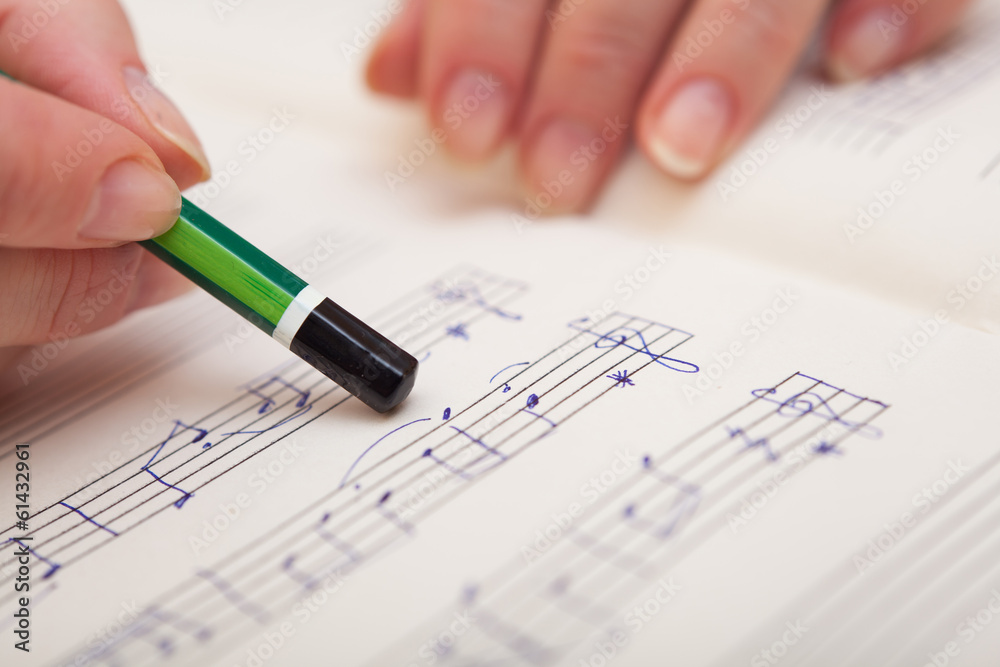 Hand with pen and music sheet Hand with pen and music sheet