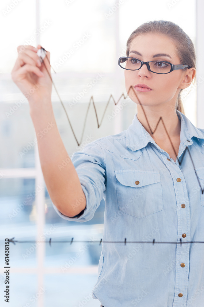Attractive businesswoman drawing a graph. Attractive businesswoman drawing a graph.