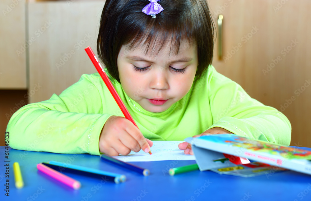 A girl draws with crayons A girl draws with crayons