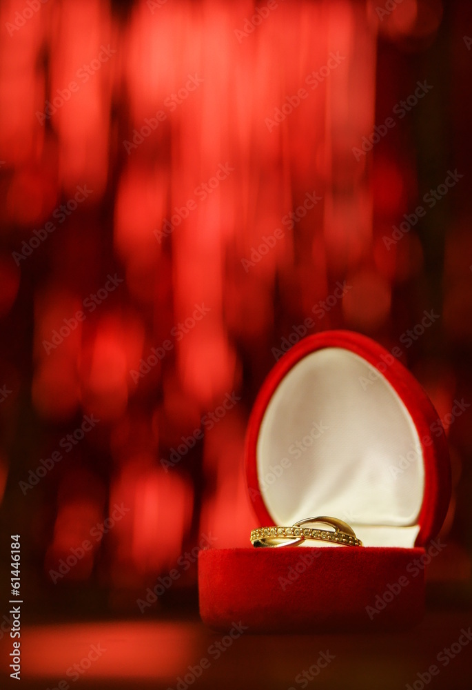 złoty pierścionek w czerwonym pudełku na czerwonym tle pion - obrazy, fototapety, plakaty 