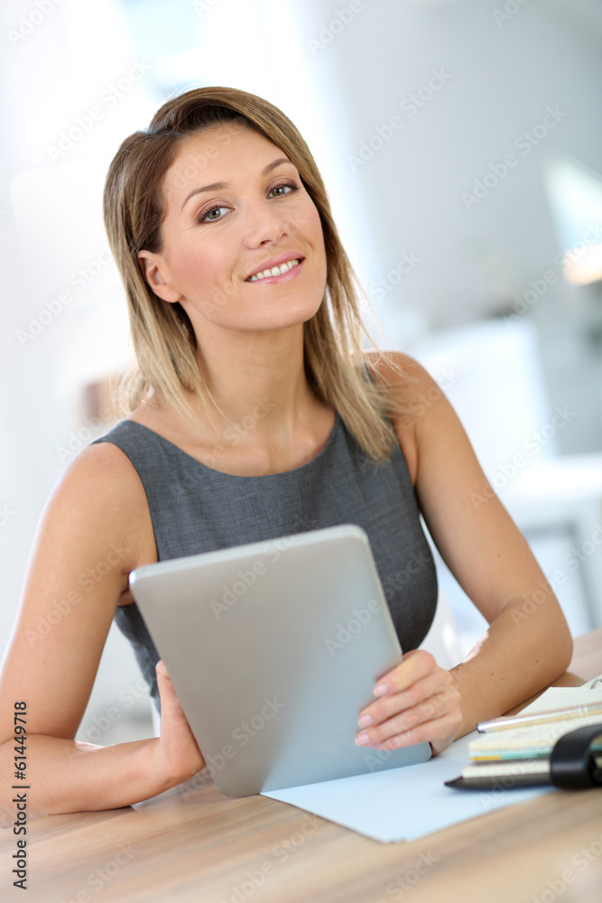 Businesswoman in office working on digital tablet Businesswoman in office working on digital tablet