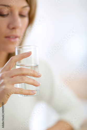 Closeup on glass of water held by woman's hand