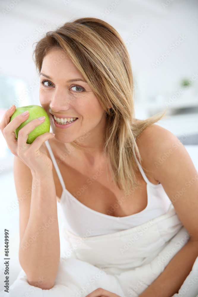 Beautiful woman giving bite to green apple Beautiful woman giving bite to green apple