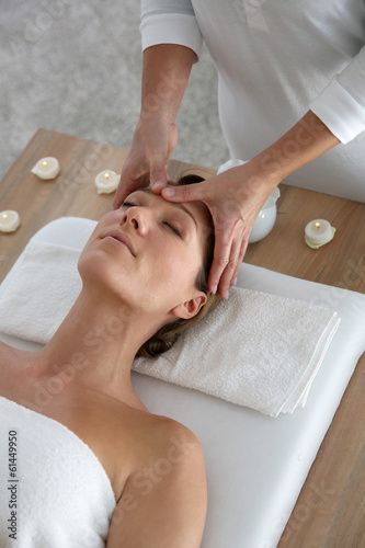 Фотография Woman having a face massage in beauty institute