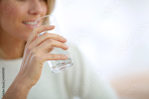 Closeup on glass of water held by woman's hand