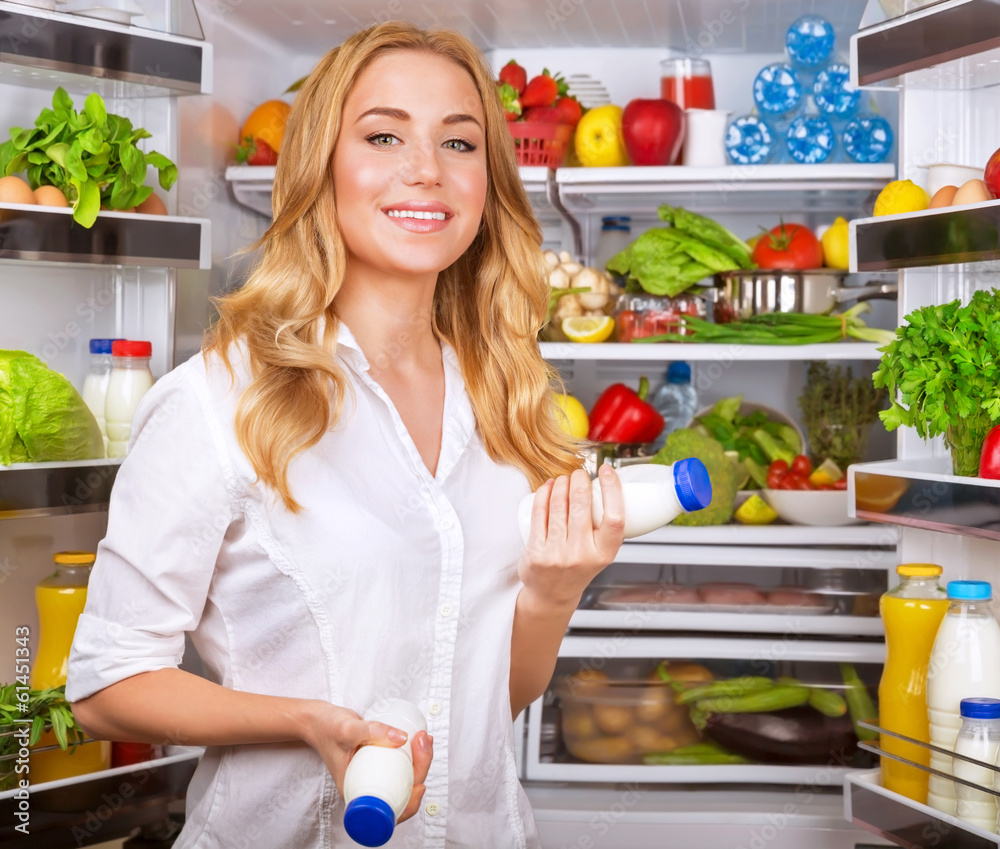 Woman chosen yogurt in opened refrigerator Woman chosen yogurt in opened refrigerator