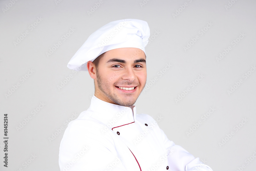 Professional chef in white uniform and hat, on gray background Professional chef in white uniform and hat, on gray background