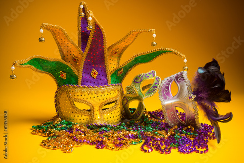 Colorful group of Mardi Gras or venetian mask on yellow