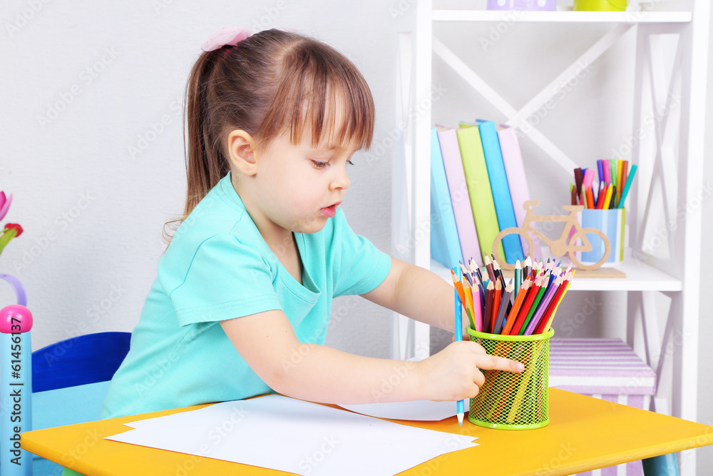 Little girl draws sitting at table in room Little girl draws sitting at table in room