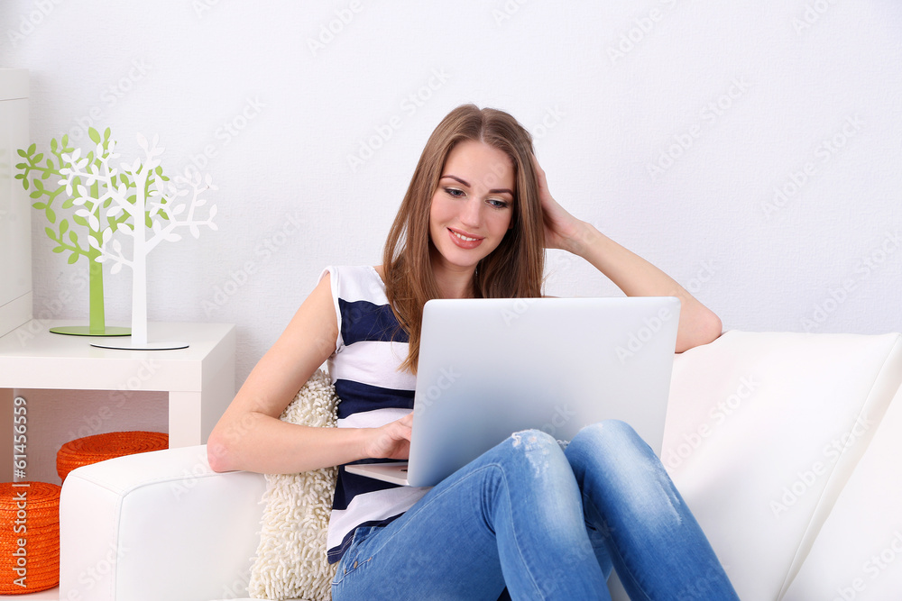 Young woman resting with laptop on sofa at home Young woman resting with laptop on sofa at home