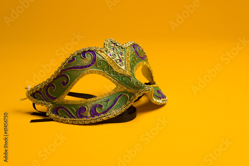 Green and gold Mardi Gras, venetian mask on Yellow background
