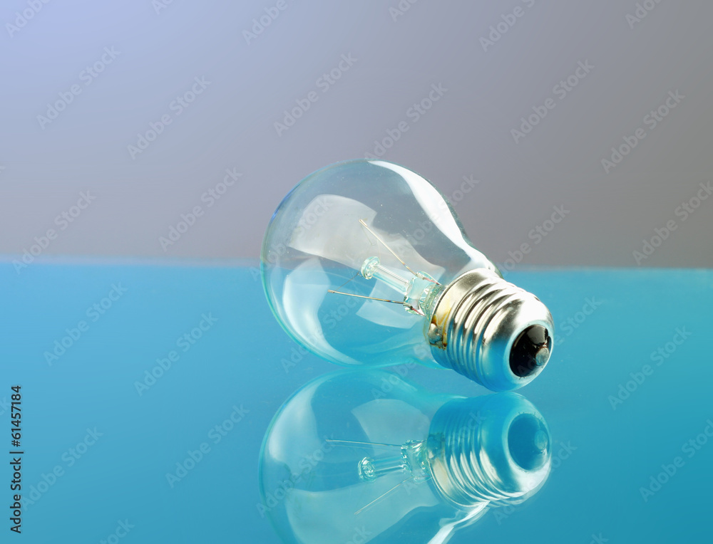 Light bulb isolated on blue glossy background. Light bulb isolated on blue glossy background.