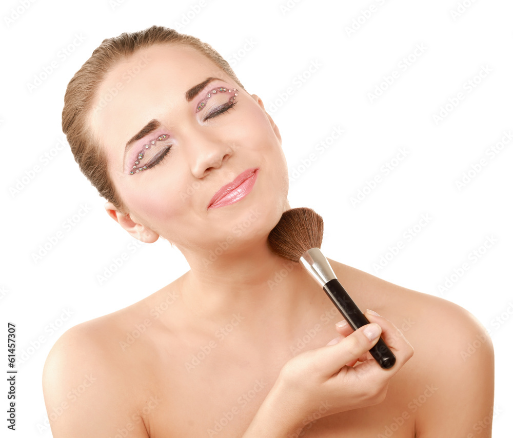 Beautiful young woman holds the make-up brushes