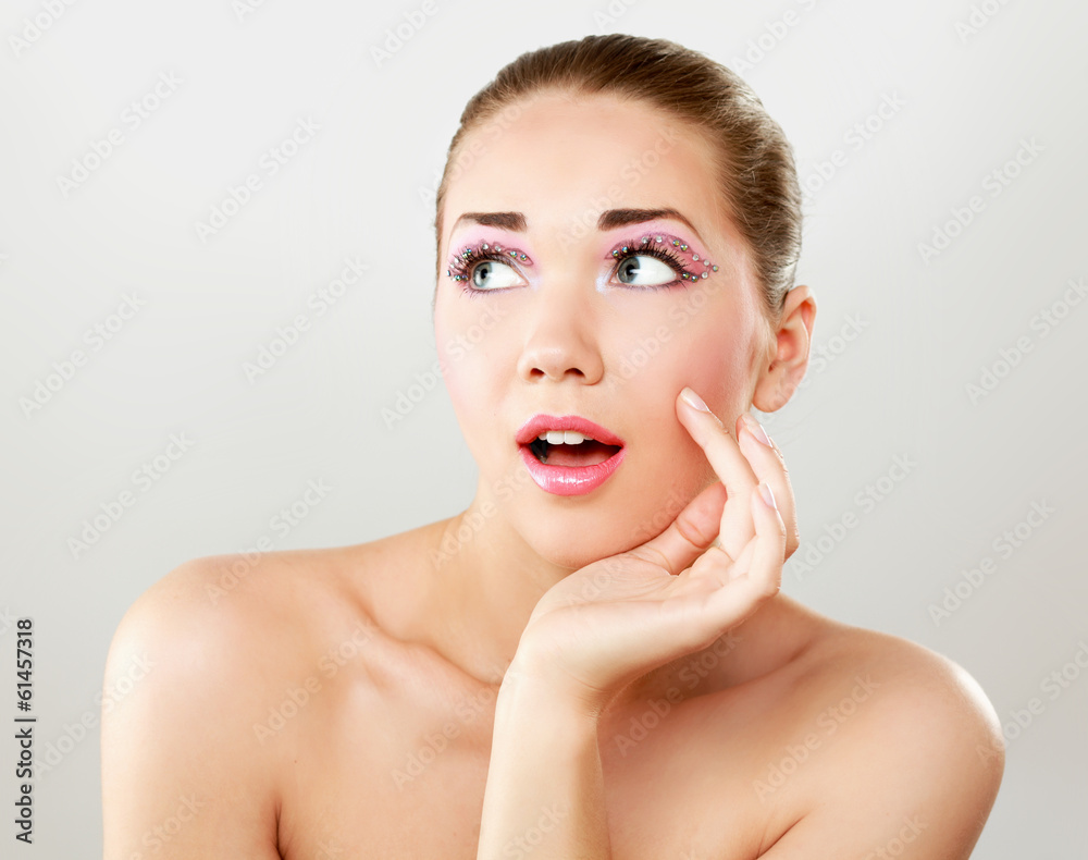 A beautiful young woman touching her face A beautiful young woman touching her face
