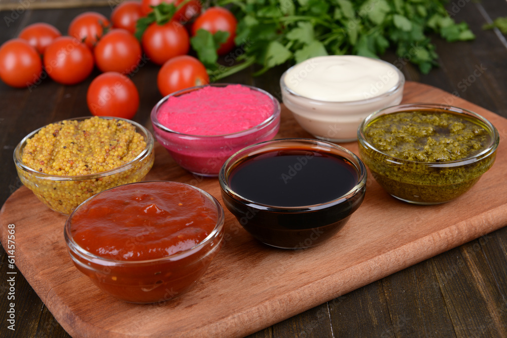 Various sauces on chopping board on table close-up Various sauces on chopping board on table close-up