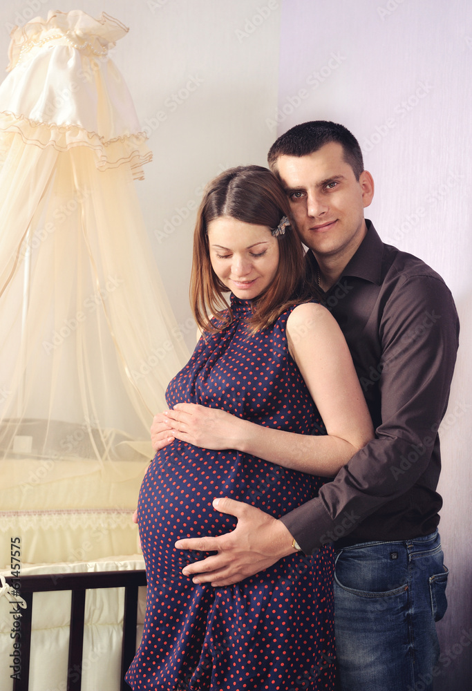Couple future parents near a cot. Couple future parents near a cot.
