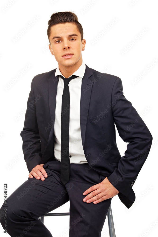 Smiling young handsome businessman at a suit sitting on chair Smiling young handsome businessman at a suit sitting on chair