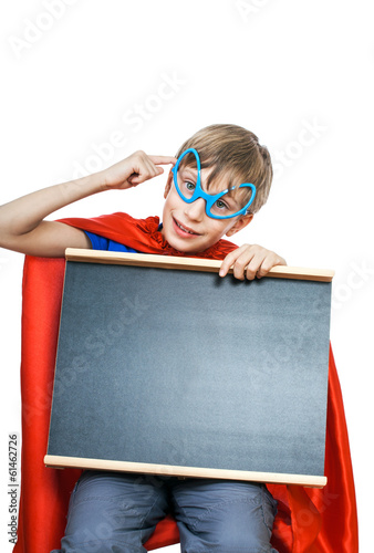 Beautiful cheerful child superhero holds black board