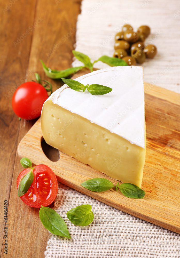 Tasty Camembert cheese with tomatoes, olives and basil,