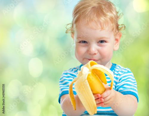 happy kid eating banana fruit. healthy food eating concept.