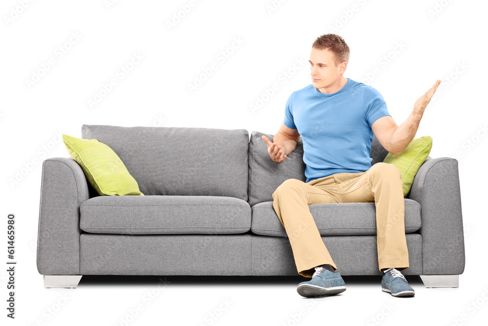 Angry man sitting on couch and violently swinging his hand Angry man sitting on couch and violently swinging his hand