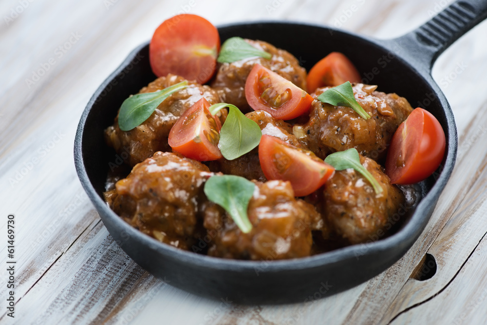 Frying pan with meatballs, tomatoes and corn salad, close-up Frying pan with meatballs, tomatoes and corn salad, close-up