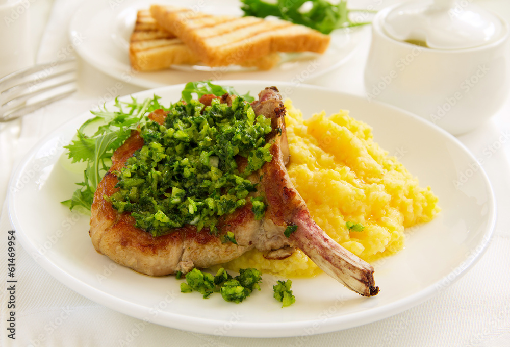 natural cutlet on the bone with polenta and gremolatoy. natural cutlet on the bone with polenta and gremolatoy.