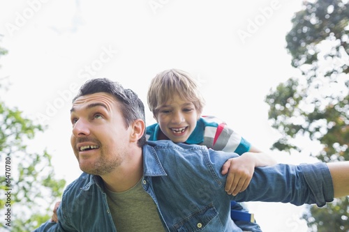 Father carrying cheerful boy on back © WavebreakmediaMicro