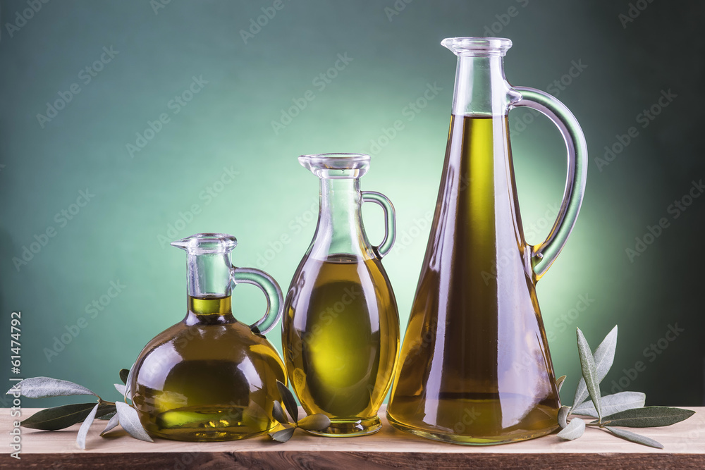 Jarras de cristal con aceite de oliva virgen extra y hojas