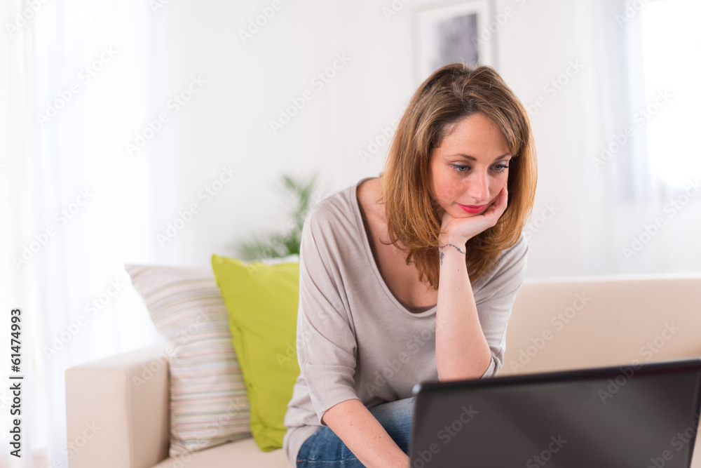 Cheerful young women at home with laptop