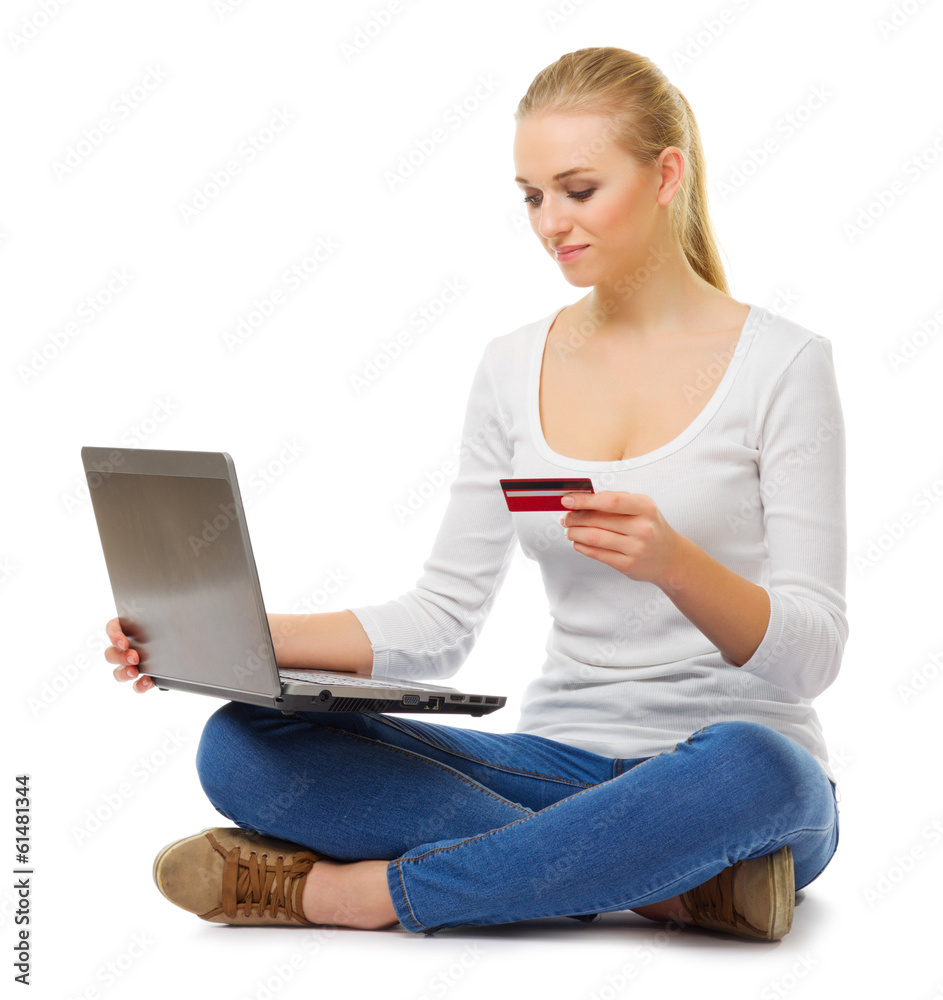 Naklejka premium Young girl in jeans with laptop and credit card