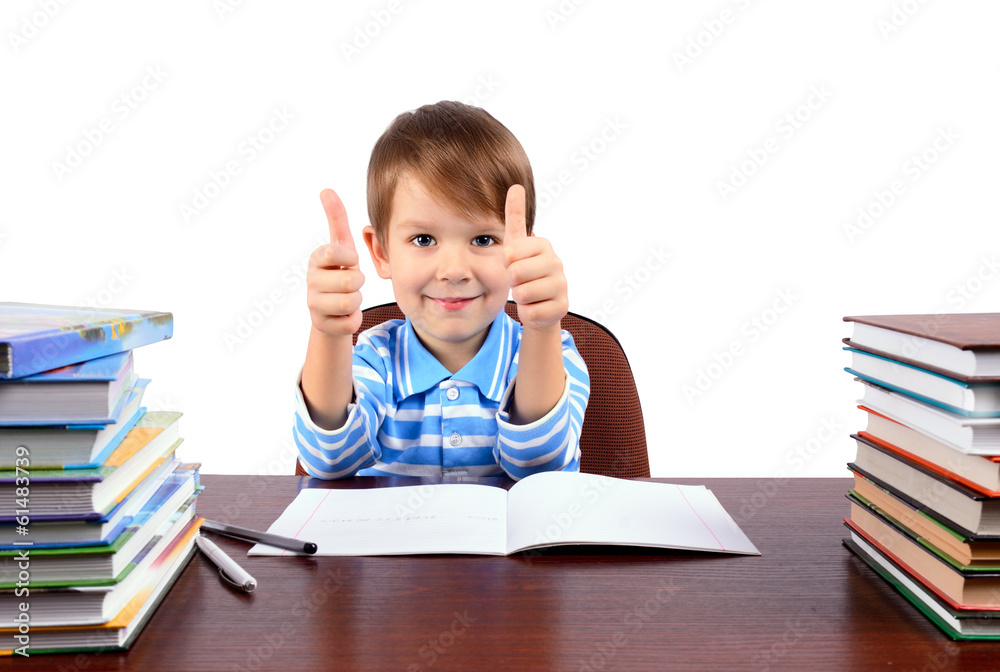 boy at the desk shows thumbs up boy at the desk shows thumbs up